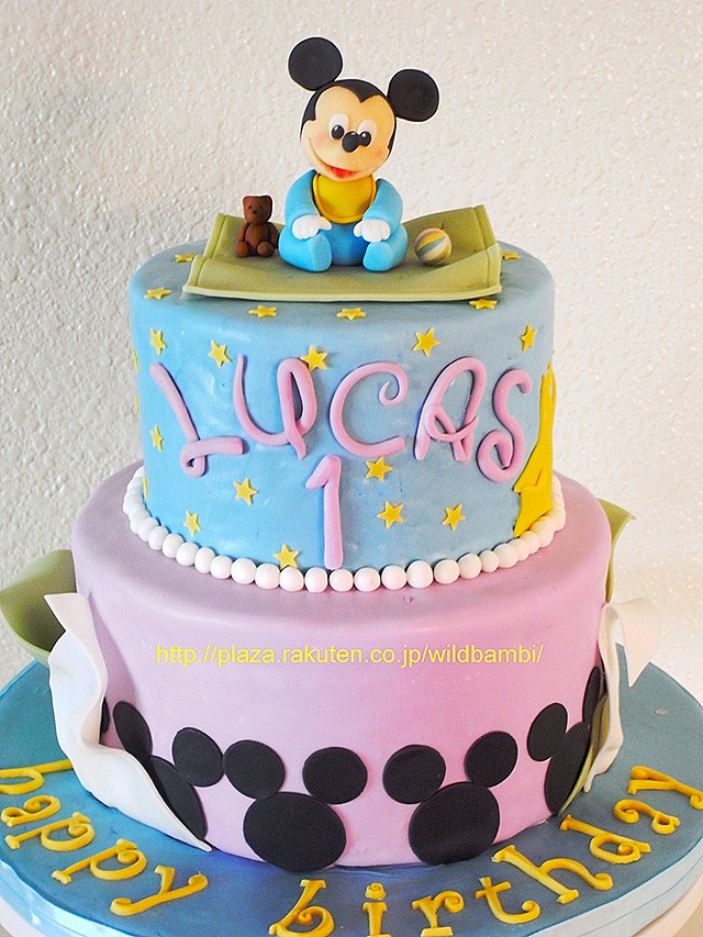 A red color mickey cake with mickey face on top and caricature in front  with a cute 1 made with fondant – Creme Castle