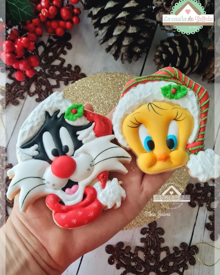 Tweety is wearing a red and green striped stocking cap, while Sylvester is wearing a Santa hat.